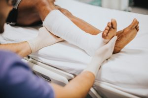 Doctor holding broken leg on bed.