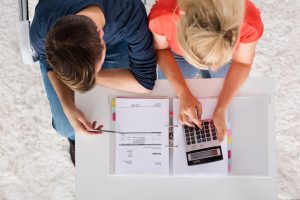 Couple at desk with calculator.